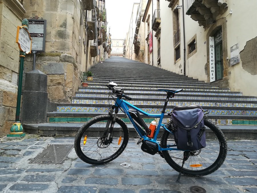 Vélo électrique au pied de l'escalier de Santa Maria del Monte à Caltagirone, orné de carreaux de céramique