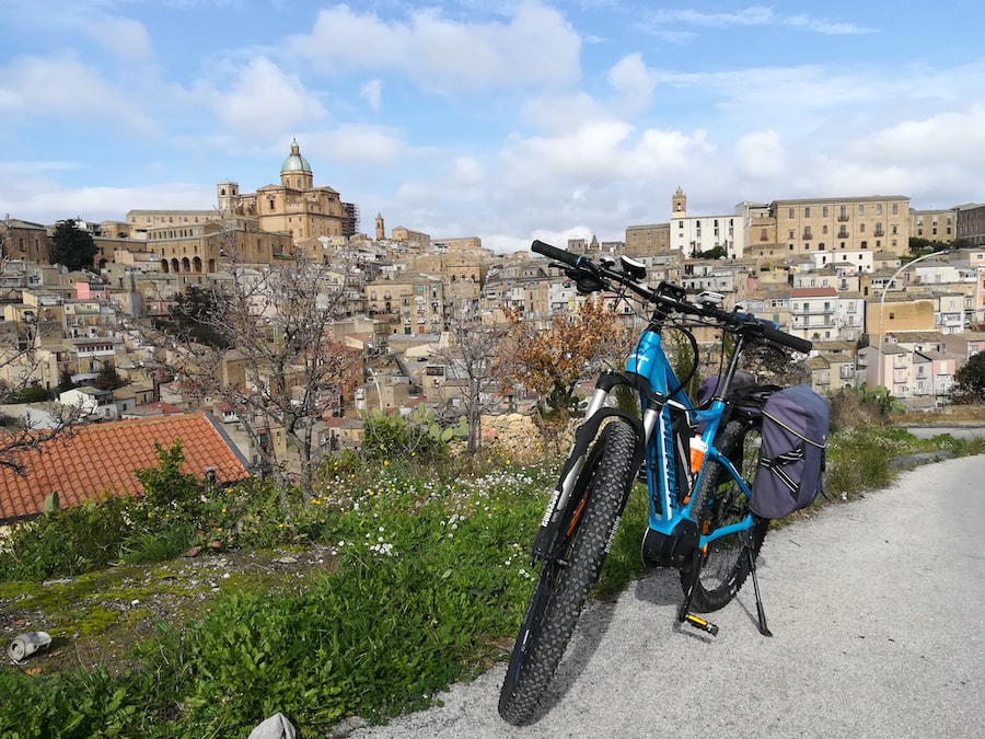 Piazza Armerina et sa cathédrale vues d'une route panoramique, avec un vélo de location au premier plan